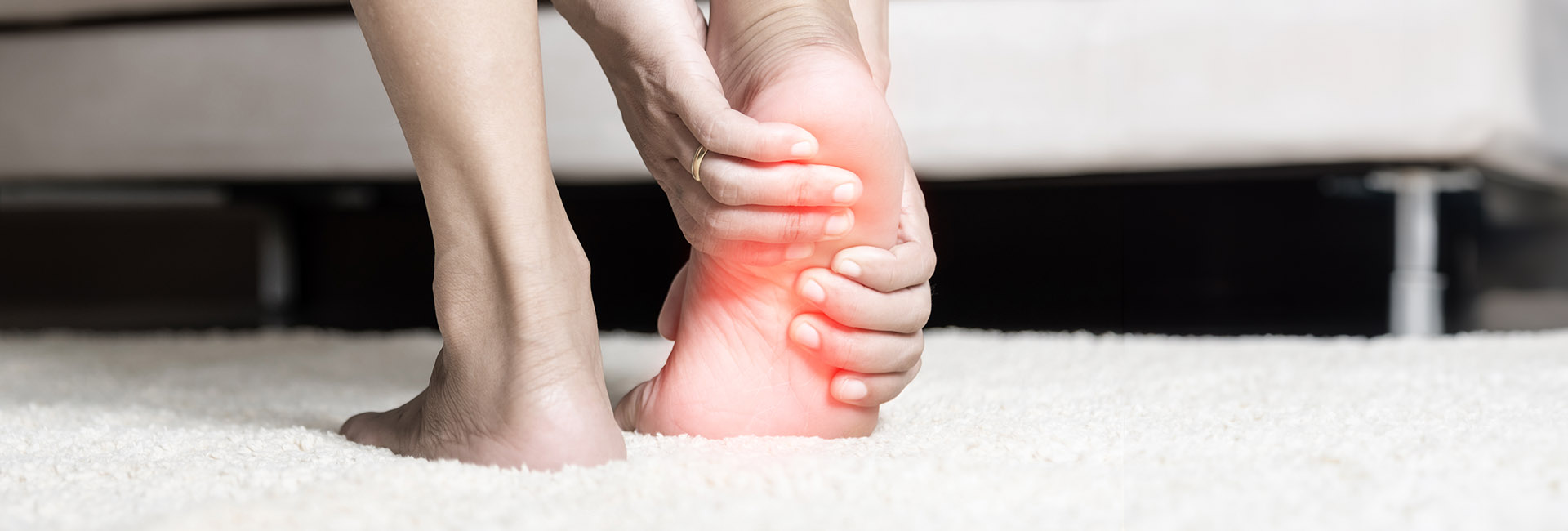 Person holding the heel and arch of their foot